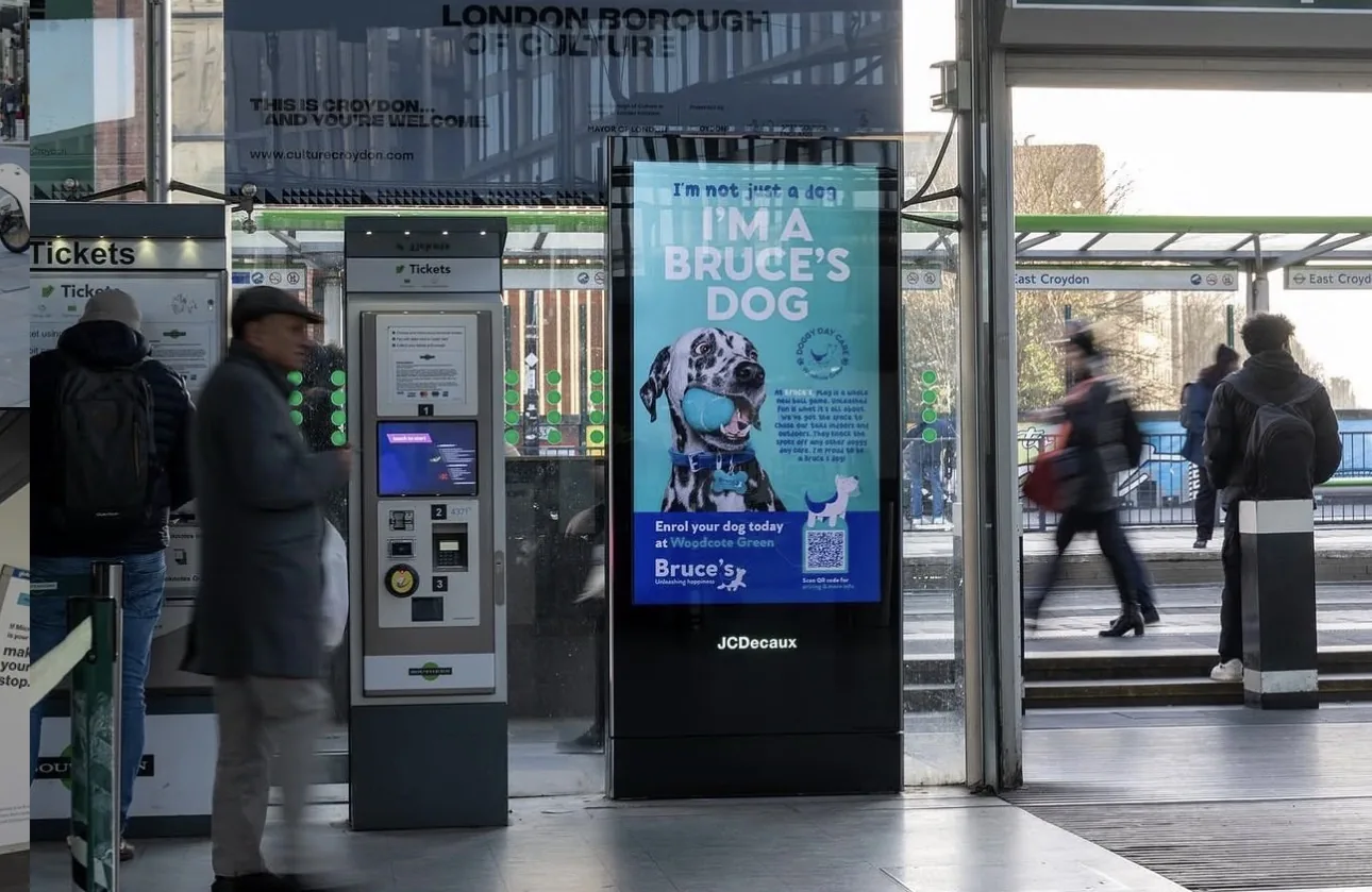 Digital out-of-home advertising screen inside a busy railway station